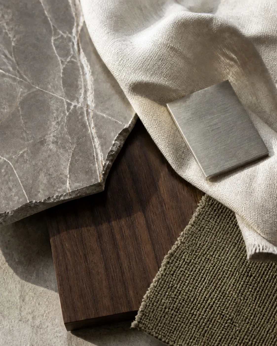 Stone, walnut, linen and brushed metal samples laid together